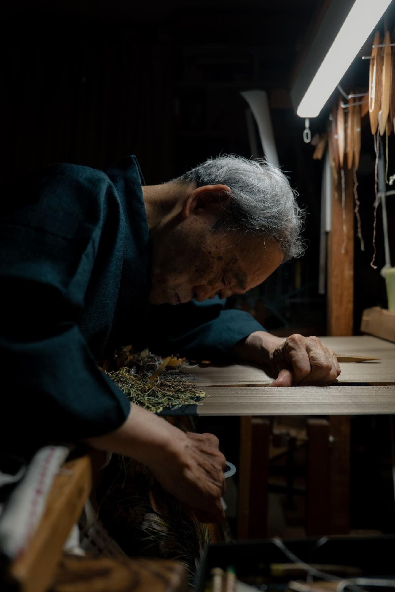 織機に向かう職人。ブランド提供の工芸資料。