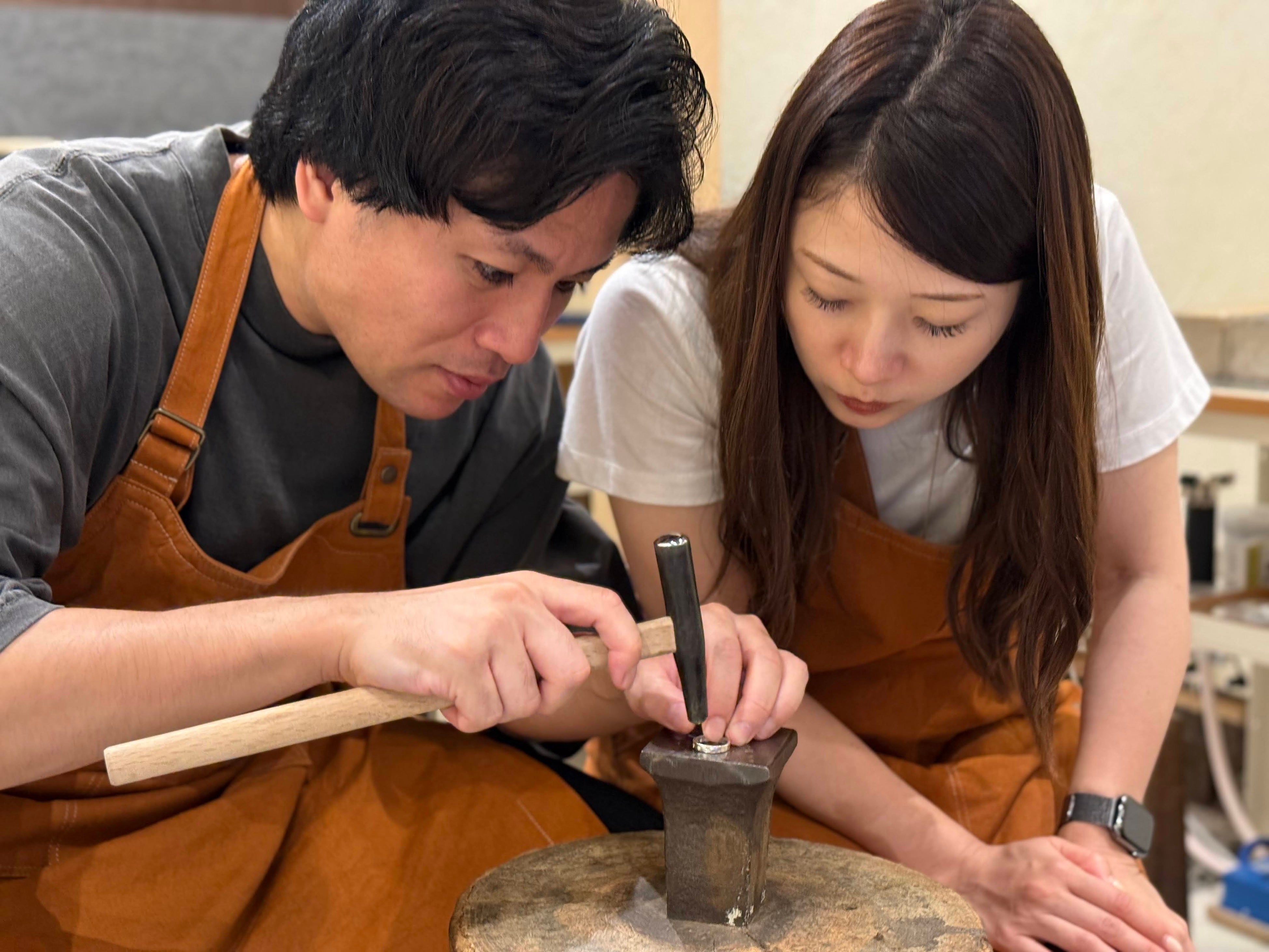 Two participants use tools together to make a ring.